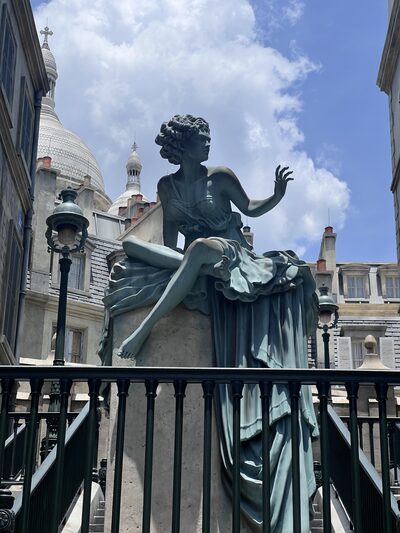 Bronze statue against Beaux-Arts architecture in the Wizarding World at Epic Universe